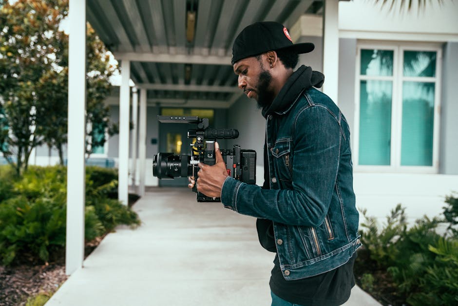 A professional wedding videographer holding a camera at an event